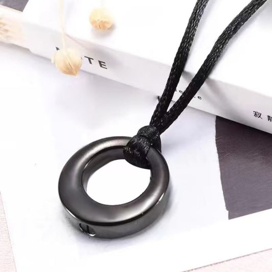 Black hollow circle memorial pendant necklace lifestyle photo on display surface