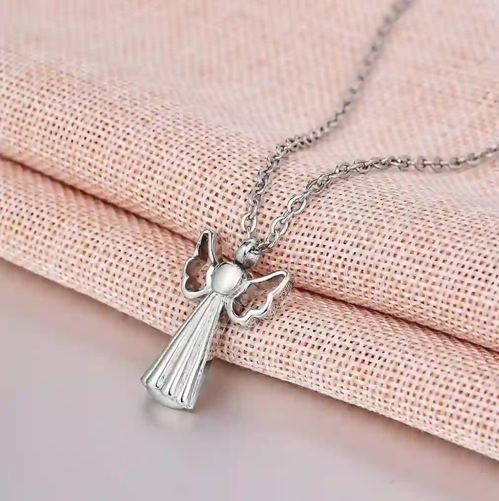 Angel wings pet urn necklace sitting elegantly on a soft pink background.