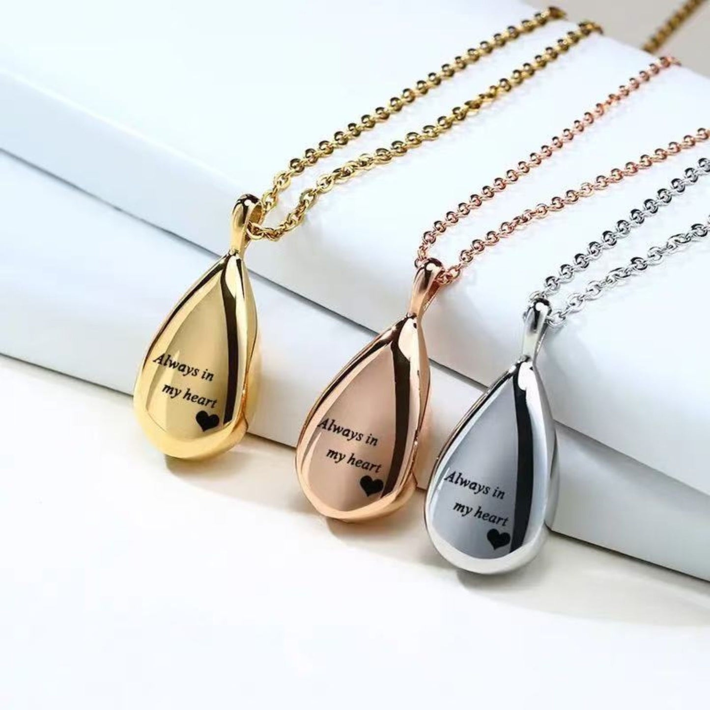 Silver, gold and rose gold teardrop urn pendants with screw closure pieces shown