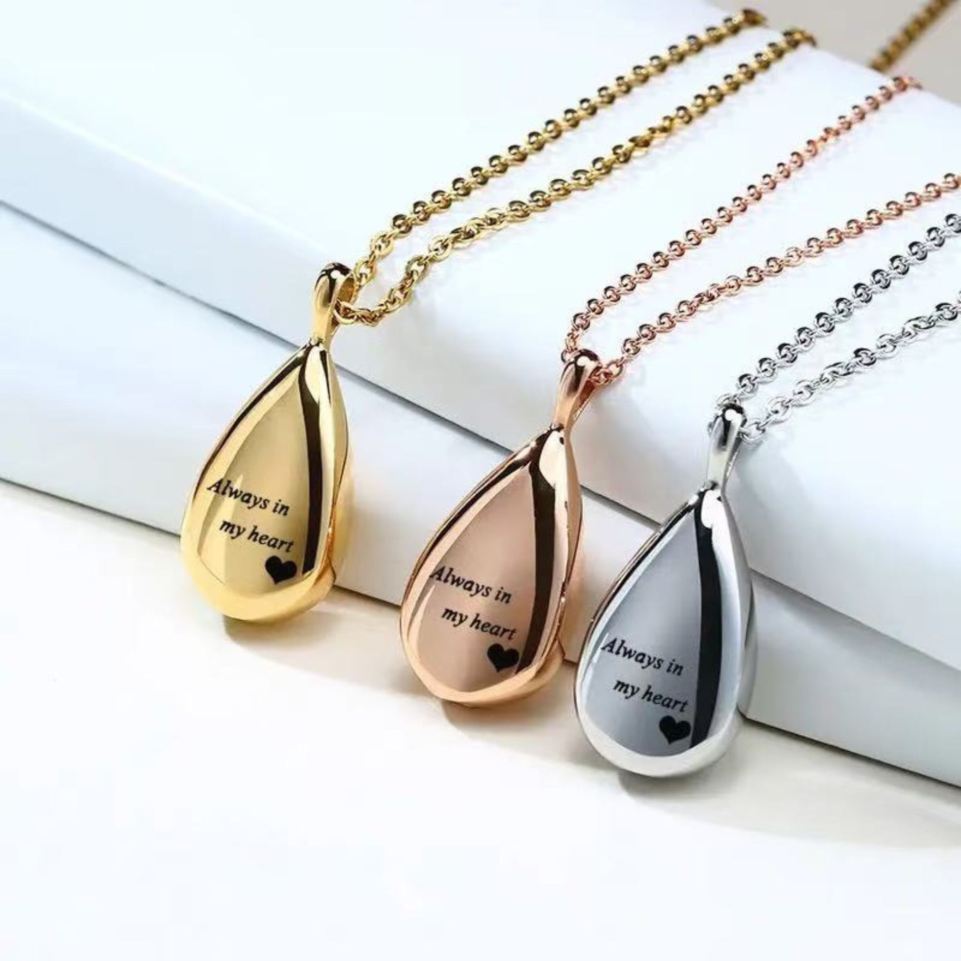 Silver, gold and rose gold teardrop urn pendants with screw closure pieces shown