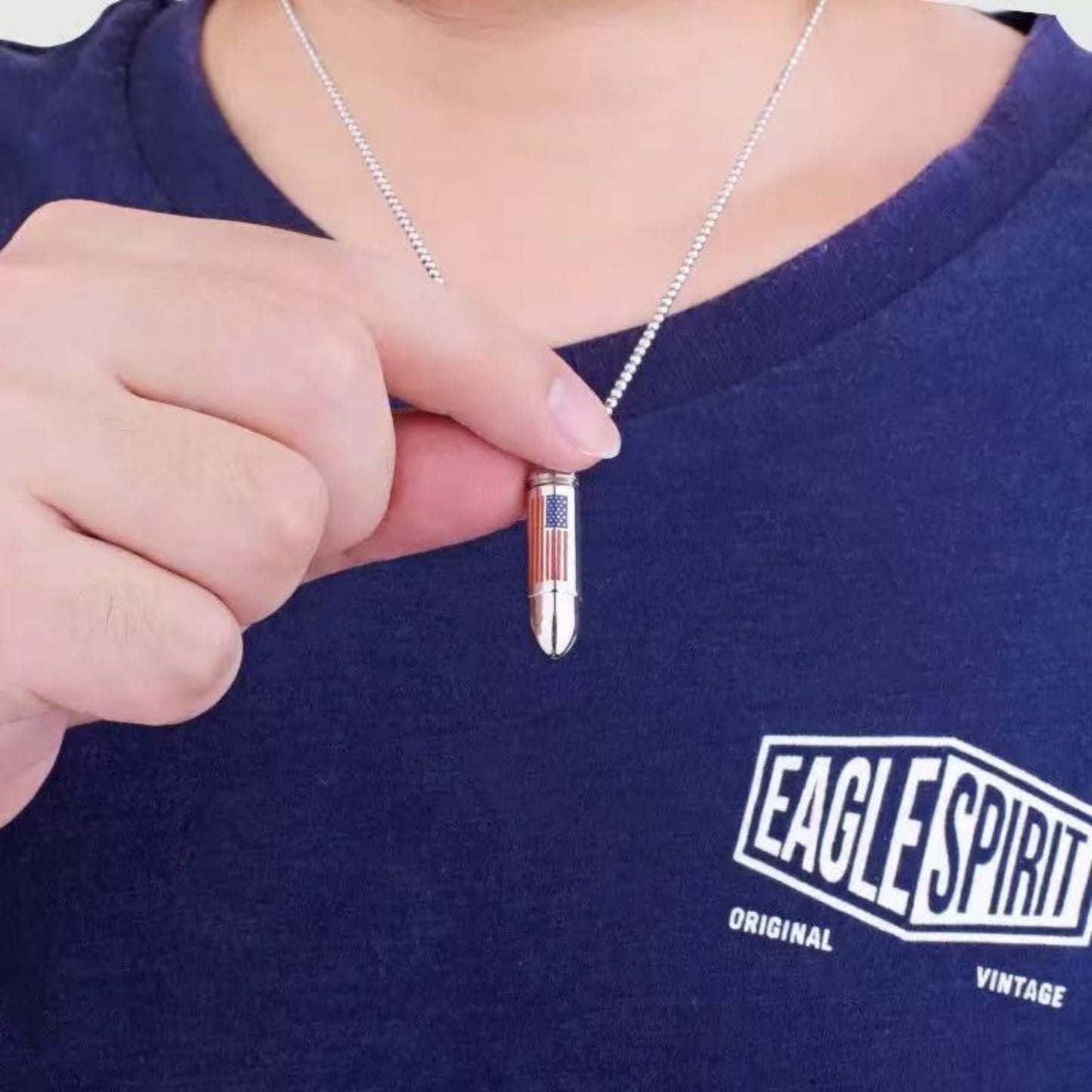 Person wearing American flag bullet urn necklace on stainless steel chain