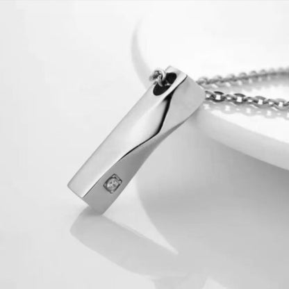 Stainless steel twisted bar urn pendant with birthstone crystal detail on surface
