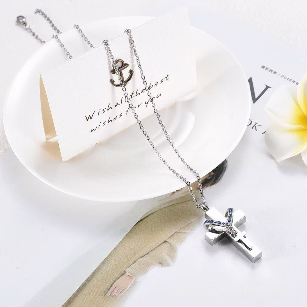 Close-up of stainless steel cross memorial pendant with blue birthstone crystals