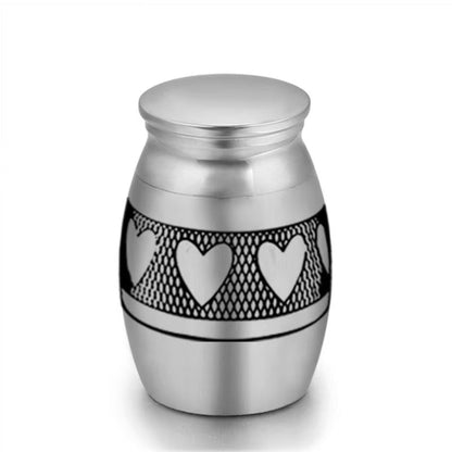 Close-up of stainless steel mini pet keepsake urn with heart pattern band design