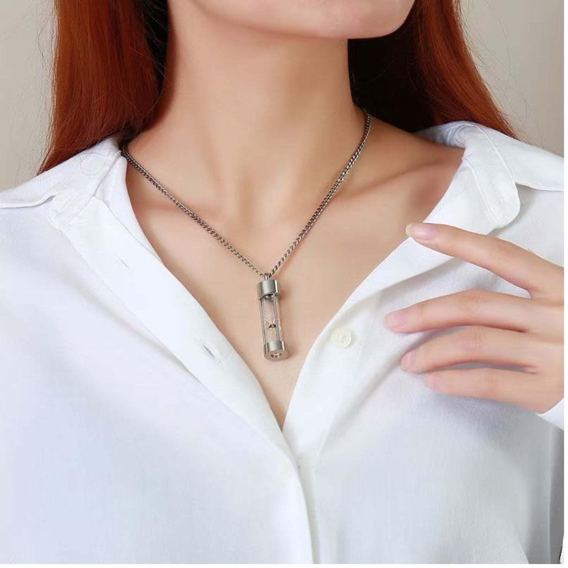 Model wearing silver hourglass glass urn memorial necklace, unisex keepsake pendant.