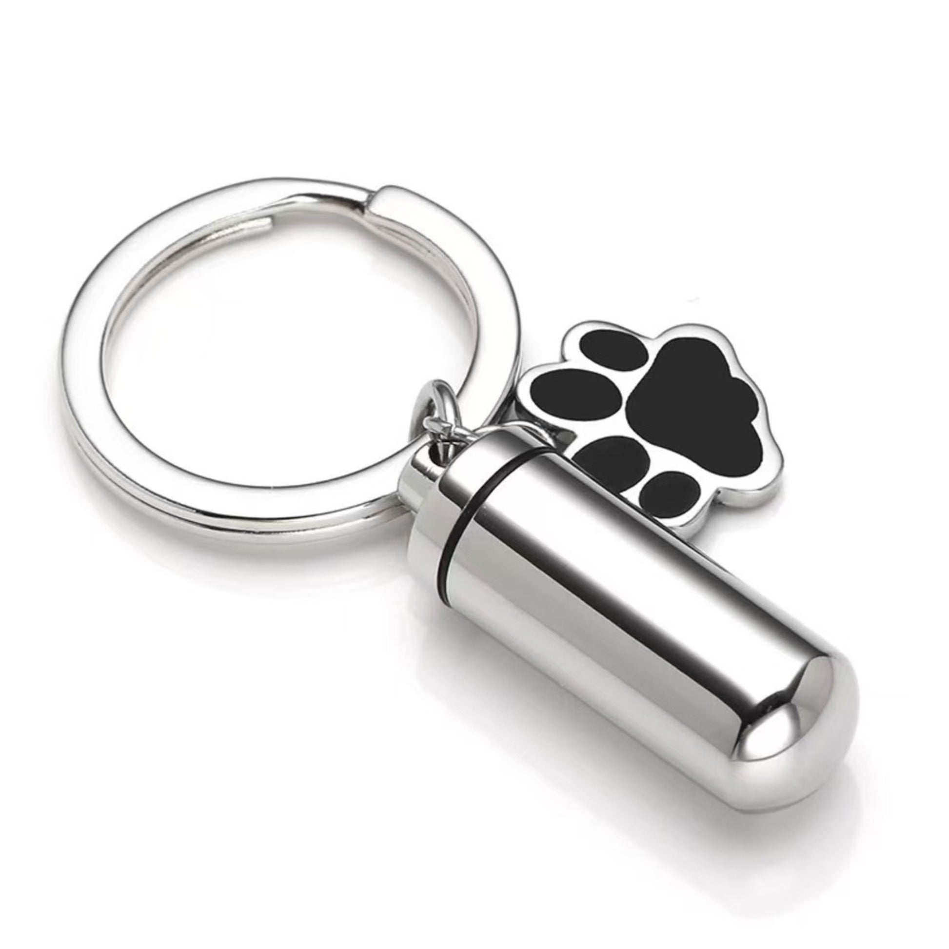 Silver stainless steel pet memorial ashes keychain urn with black paw charm and removable inner capsule on white background