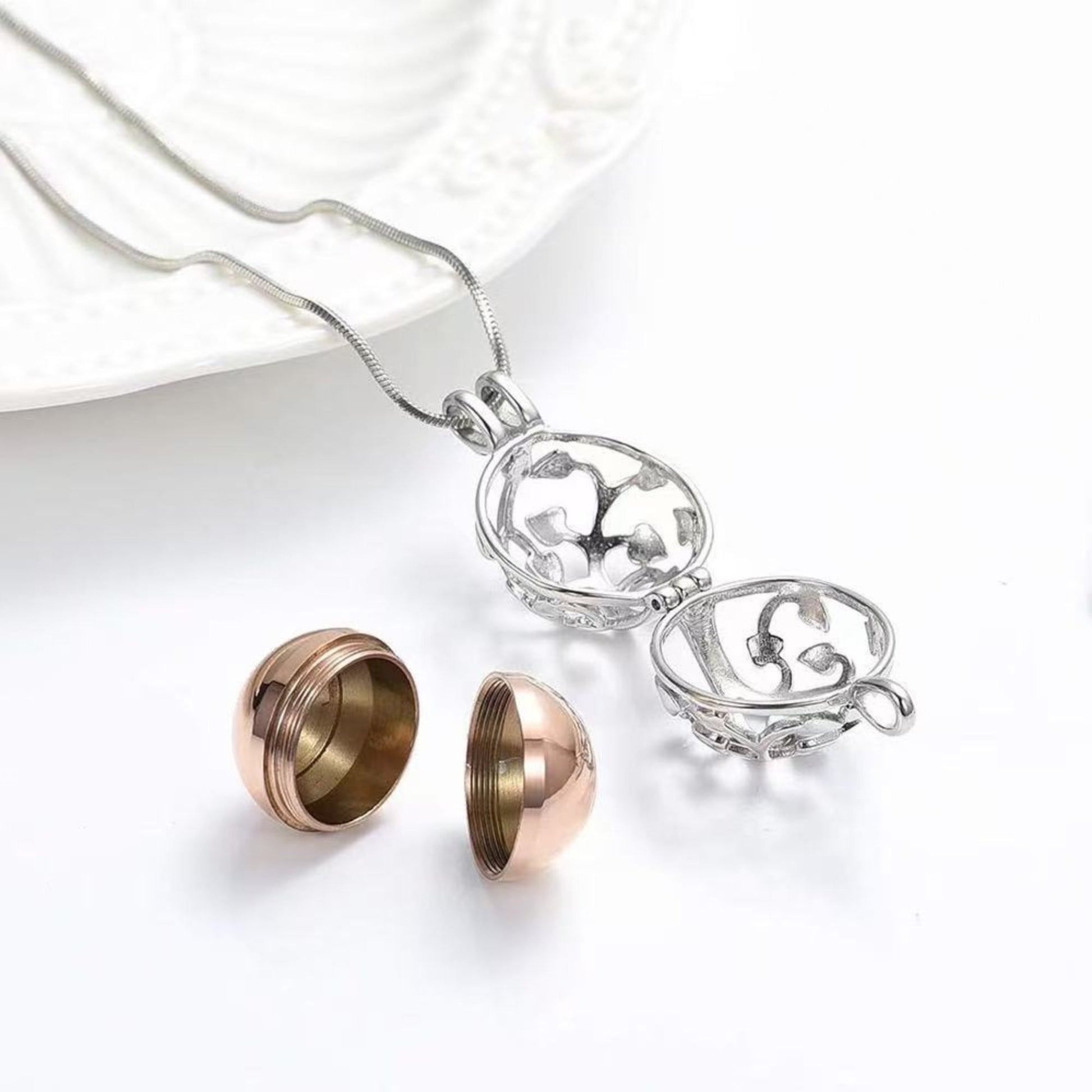 Opened Tree of Life memorial pendant showing inner sphere urn container separated into two halves