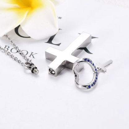 Stainless steel cross urn necklace parts shown with screw compartment and birthstone crystal heart accent
