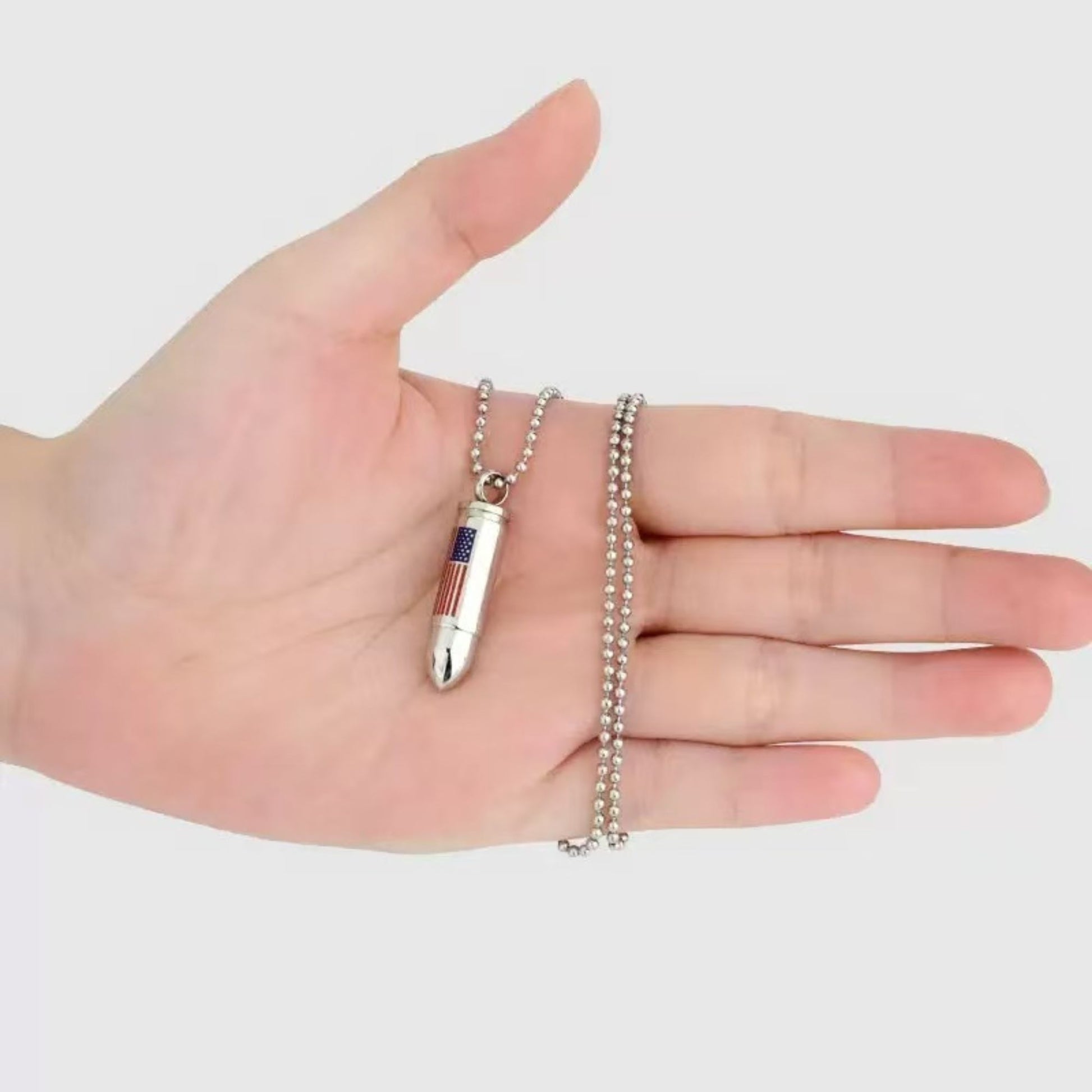 American flag bullet urn pendant display showing polished stainless steel finish