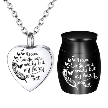 Black mini pet keepsake urn with engraved feather and butterflies beside heart cremation necklace pendant