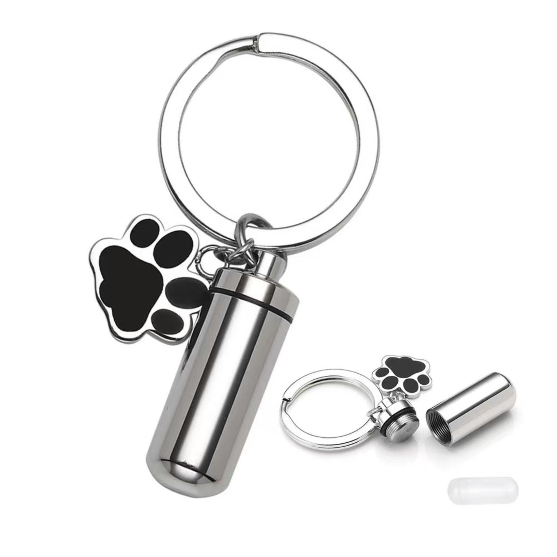 Close-up of silver pet memorial keepsake urn keychain with paw charm, opened screw-top design, and inner capsule insert