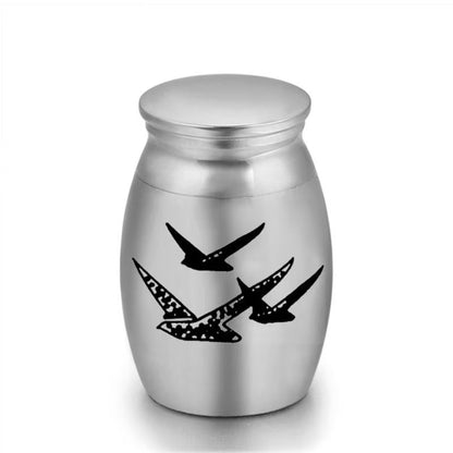 Close-up of stainless steel mini pet keepsake urn with brid design