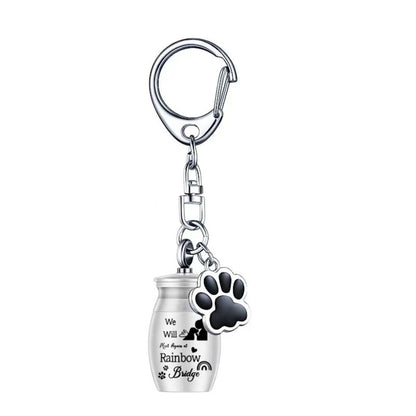 Silver Rainbow Bridge pet memorial ashes urn keychain with paw charm on white background, single item