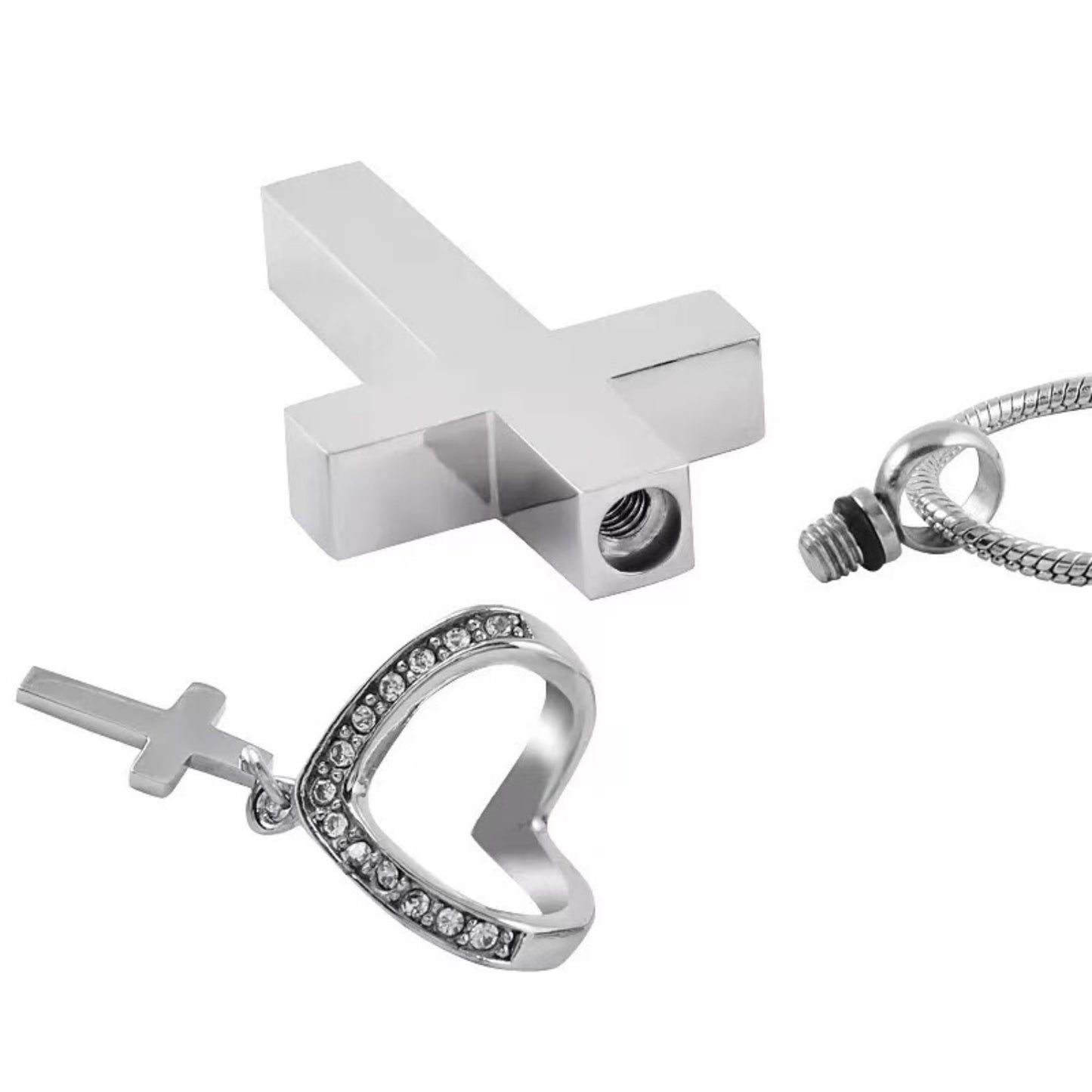 Close-up of cross urn pendant parts showing screw closure and heart accent with mini cross charm