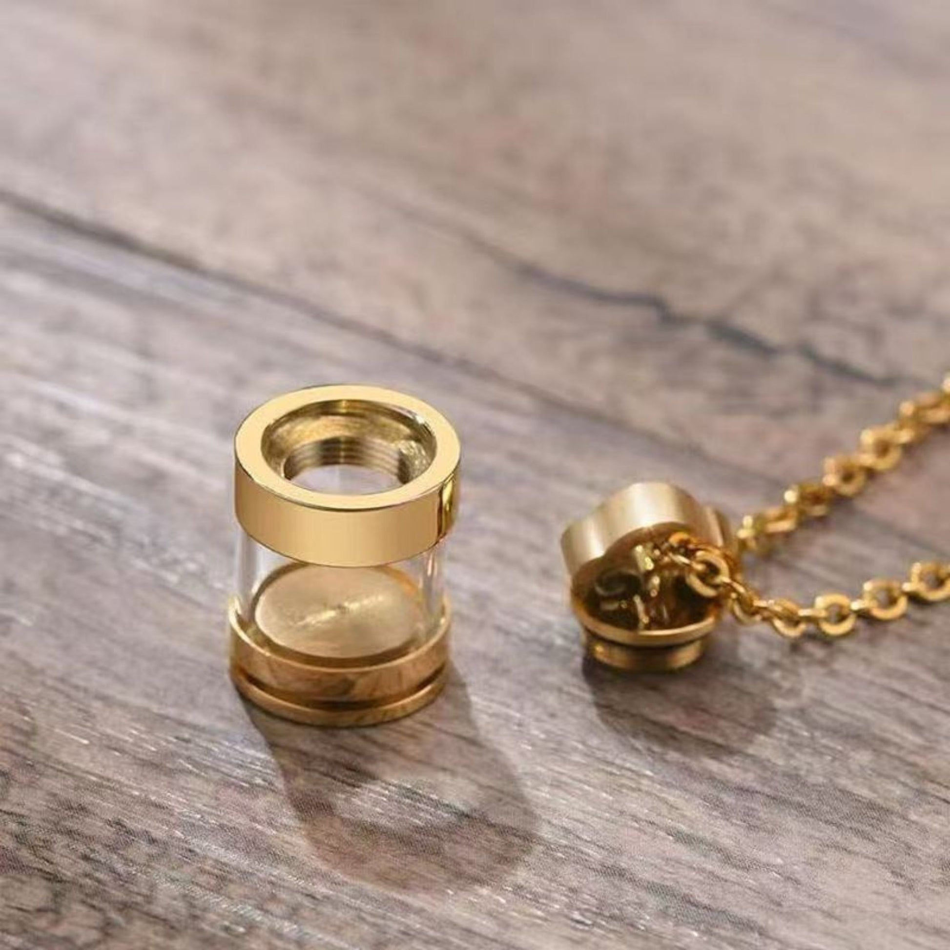 Gold clear glass urn necklace pendant with screw-top closure shown open