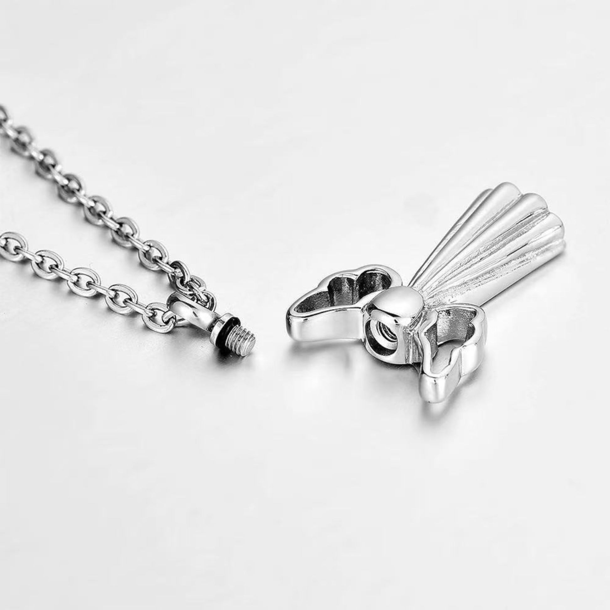 Screw-top opening of angel wings urn necklace with secure threaded cap and chain