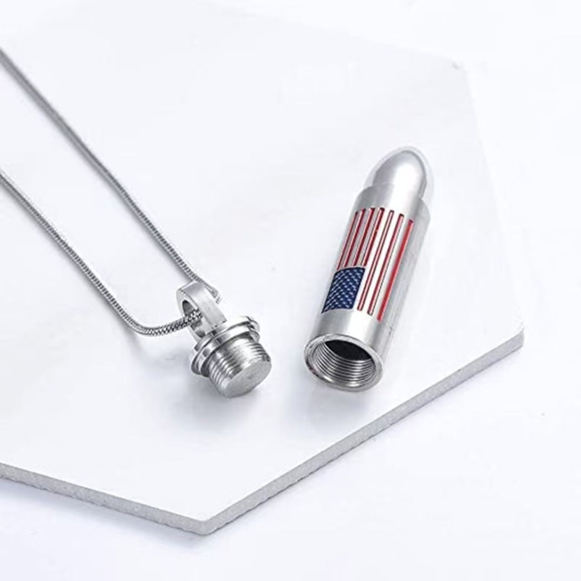 Open bullet urn pendant showing threaded screw-top compartment for ashes