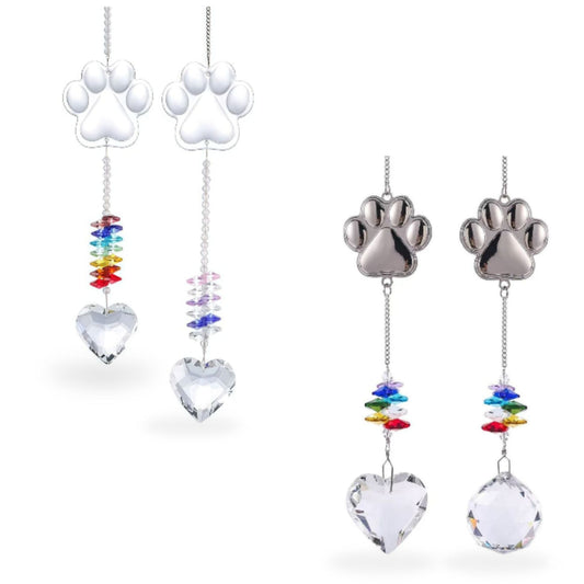 Pet loss memorial suncatcher set with unique dog paw print charms. Features two white resin paws with rainbow octagon crystals and two silver metal paws with clear heart crystal prisms. Includes rainbow beads, sympathy bereavement keepsake.