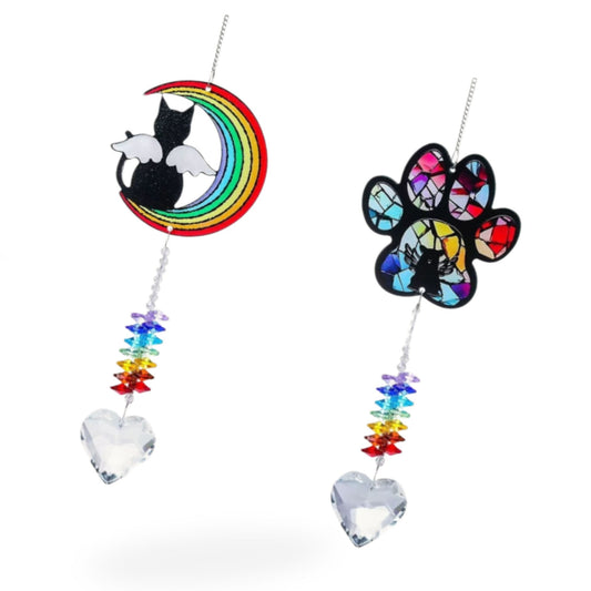 Pet memorial crystal suncatchers hanging in a window with moon cat and paw print designs and heart crystal pendants