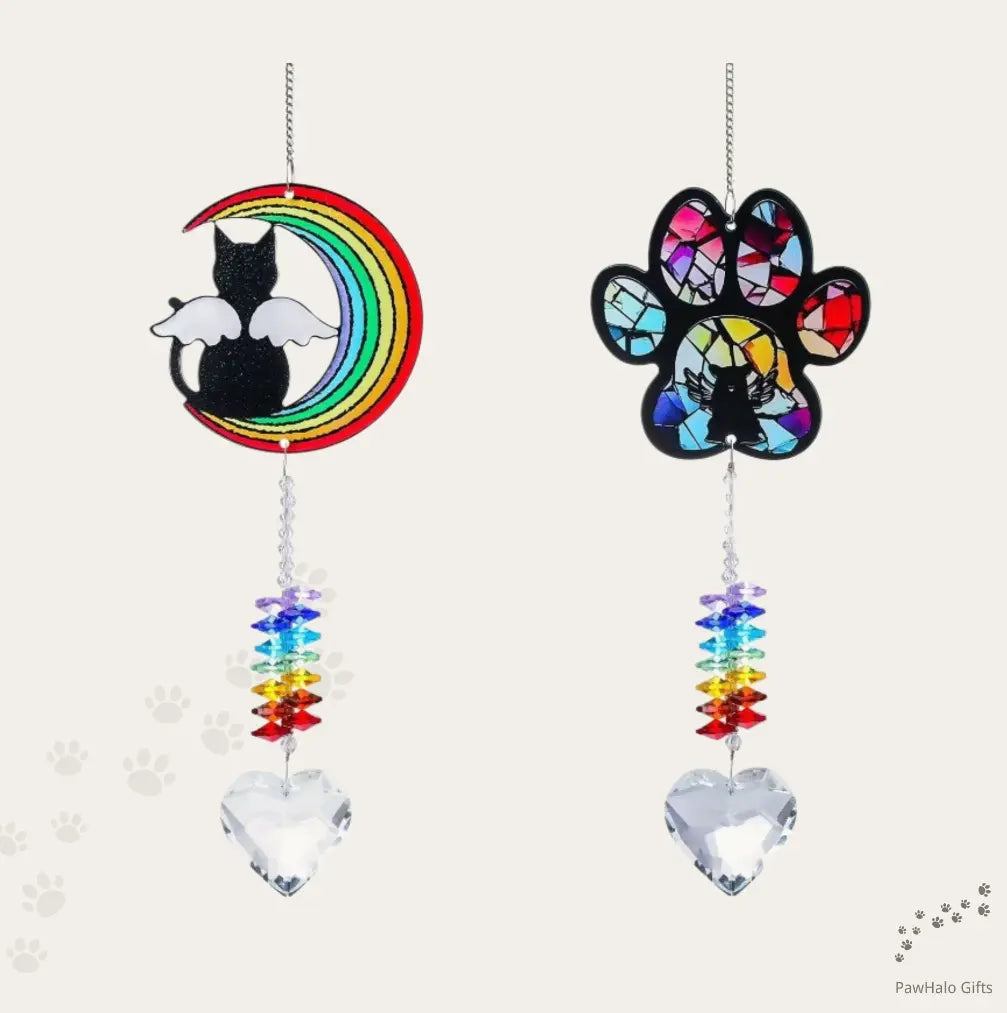 Pet memorial crystal suncatchers hanging in a window with moon cat and paw print designs and heart crystal pendants