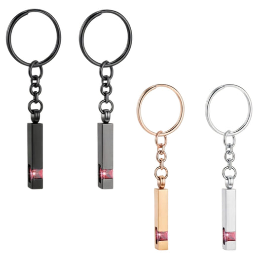 Pet memorial Urn keychain featuring a paw print design, available in black, silver, and rose gold colors. Comes with small tools (funnel, needle) for easy use, ideal for holding small keepsakes like pet fur or ashes.