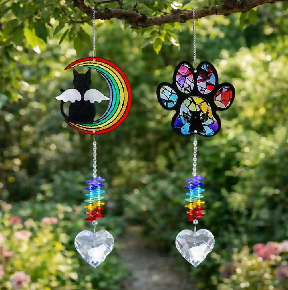 Pet memorial crystal suncatchers hanging in a window with moon cat and paw print designs and heart crystal pendants
