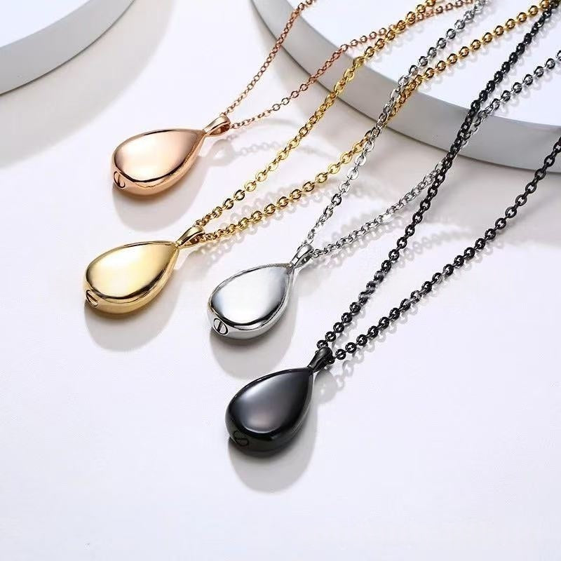 Teardrop urn necklaces in four colors laid out together showing finish options and shine