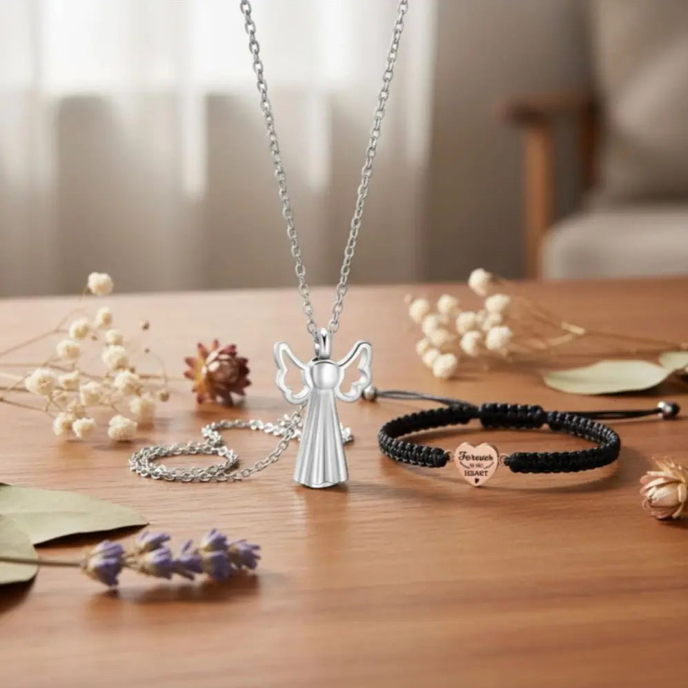 Angel pendant necklace displayed with black cord bracelet on wooden table