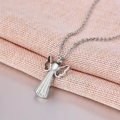 Angel wings pet urn necklace sitting elegantly on a soft pink background.