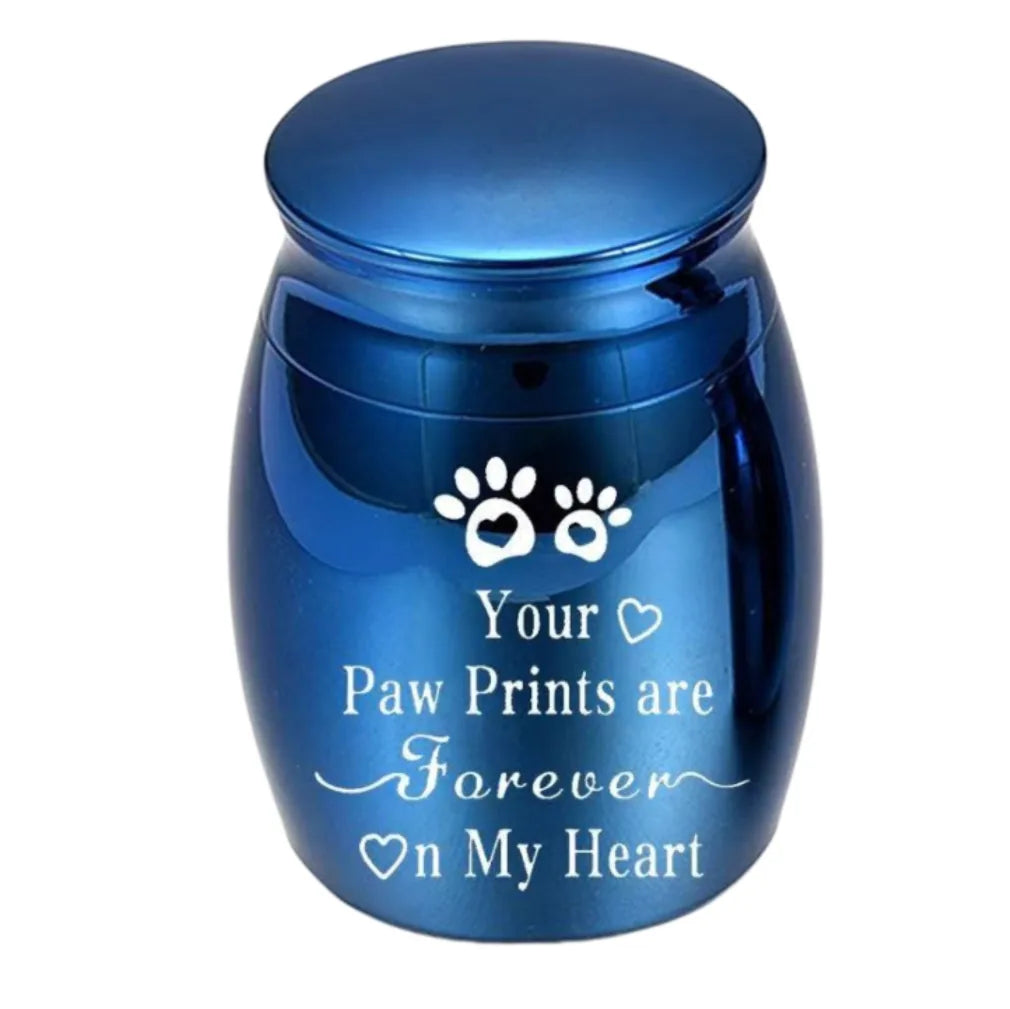 Isolated front view of the metallic blue miniature urn for cat ashes engraved with paw prints and forever on my heart text.