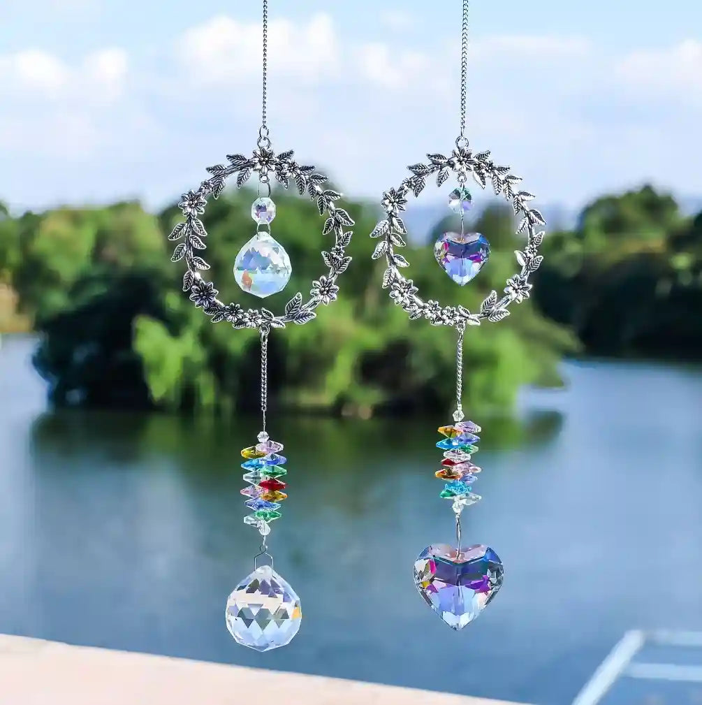 Two wreath pet memorial crystal suncatchers hanging outside over natural waterfront background.