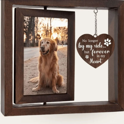 A double-sided rotating wooden pet memorial picture frame featuring a golden retriever dog photo next to a hanging heart-shaped wooden charm engraved with "No longer by my side... but forever in my heart".