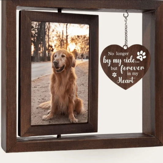 A double-sided rotating wooden pet memorial picture frame featuring a golden retriever dog photo next to a hanging heart-shaped wooden charm engraved with "No longer by my side... but forever in my heart".