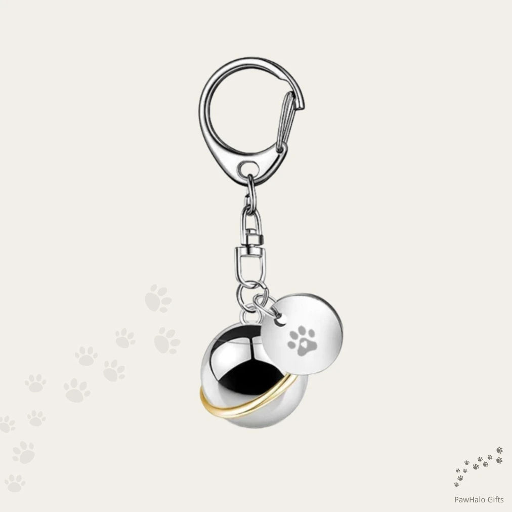 Open stainless steel round urn capsule keychain showing interior compartment and paw charm