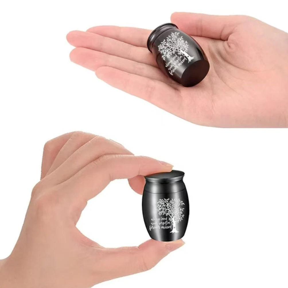 Discreet and palm-sized black pet memorial urn held in a hand to show its lightweight portable scale.