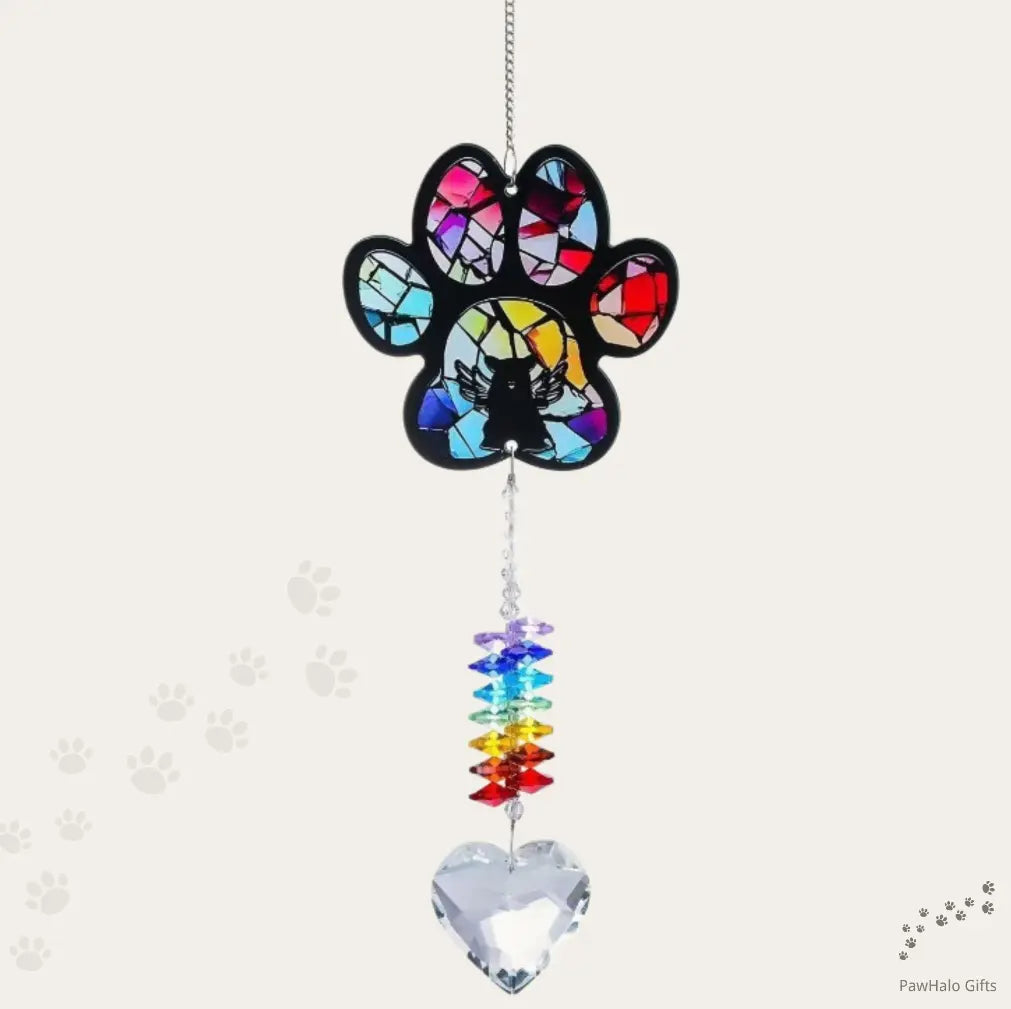 An angel dog memorial suncatcher hanging in front of a neutral background.