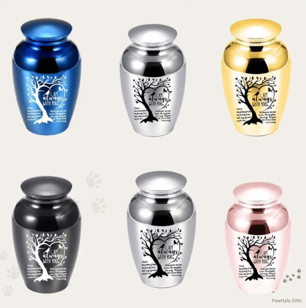 Small pet memorial urns in blue, silver, gold, black, and pink, featuring engraved tree artwork and remembrance quote for dog or cat ashes.