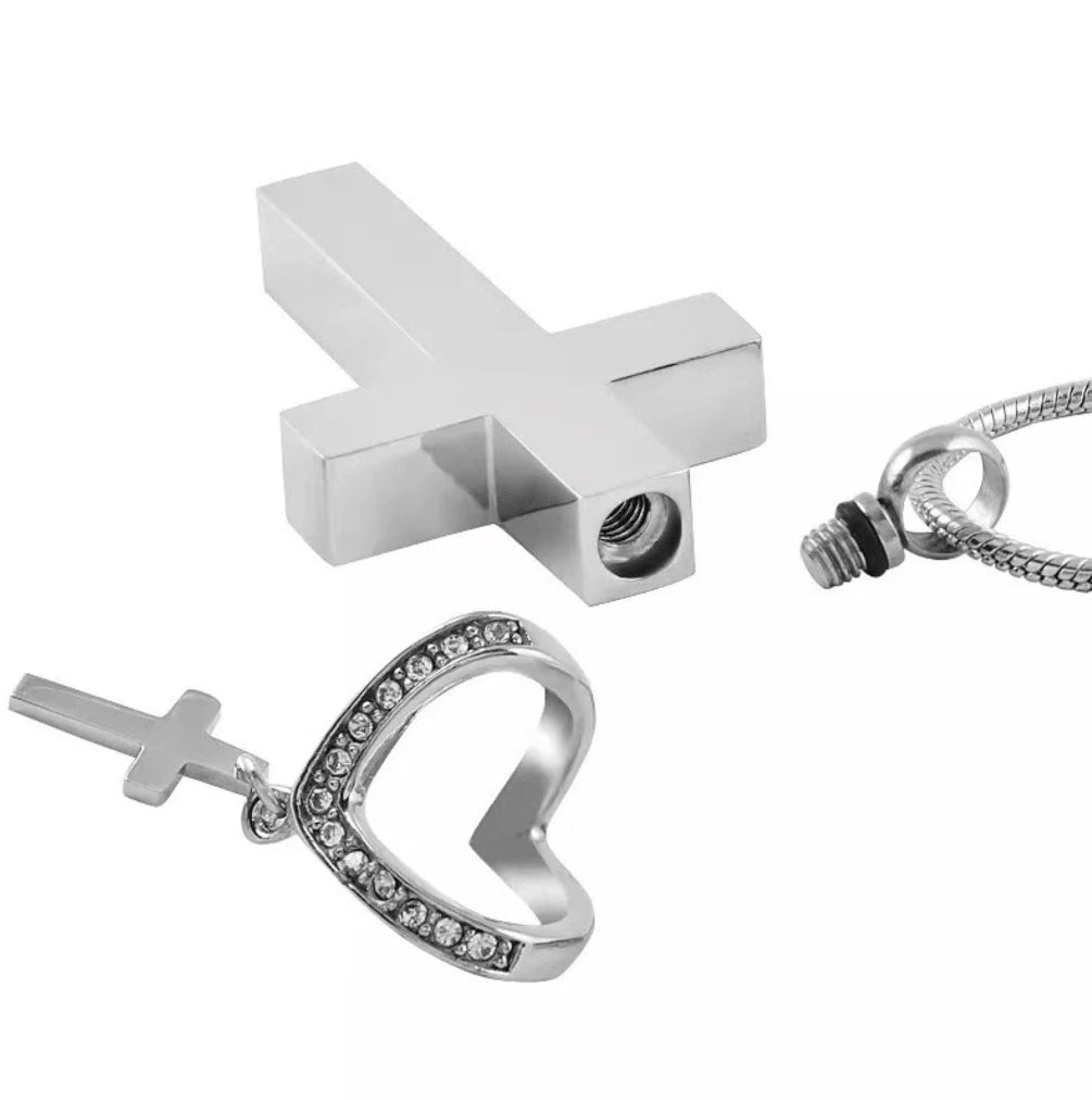 Close-up of cross urn pendant parts showing screw closure and heart accent with mini cross charm
