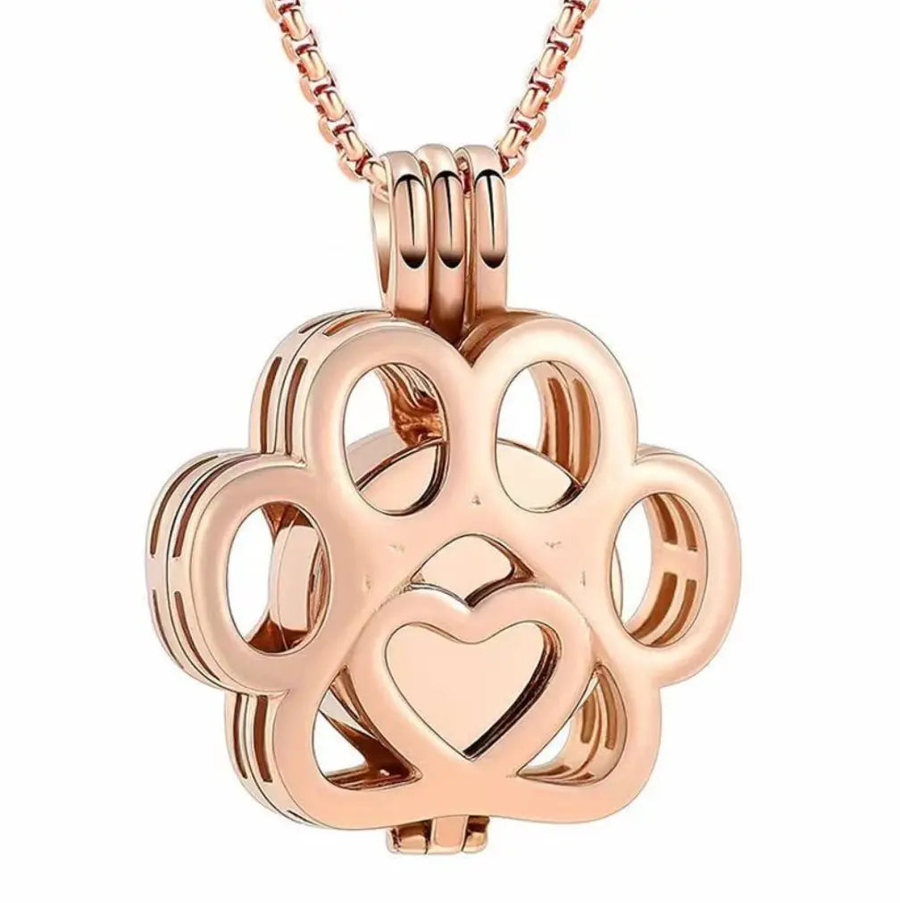 Front close-up view of the rose gold hollow paw print pet memorial keepsake pendant with fine filigree details.