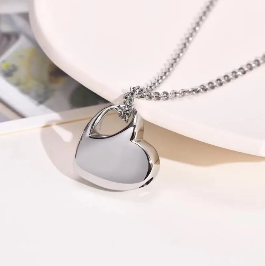 Heart urn necklace shown closed, polished stainless steel memorial keepsake