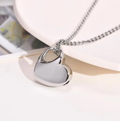 Heart urn necklace shown closed, polished stainless steel memorial keepsake