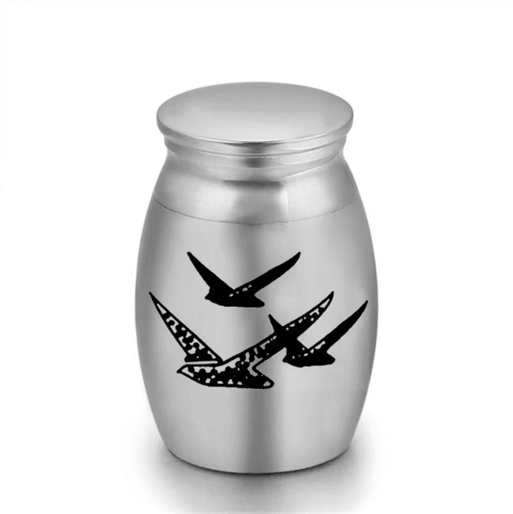 Close-up of stainless steel mini pet keepsake urn with brid design