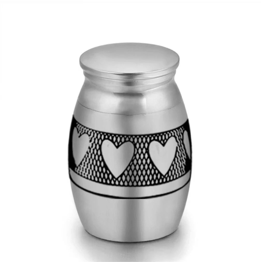 Isolated front view of the ultra-miniature 316L stainless steel pet keepsake urn featuring black laser-etched paw prints.
