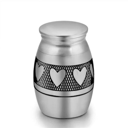 Isolated front view of the ultra-miniature 316L stainless steel pet keepsake urn featuring black laser-etched paw prints.