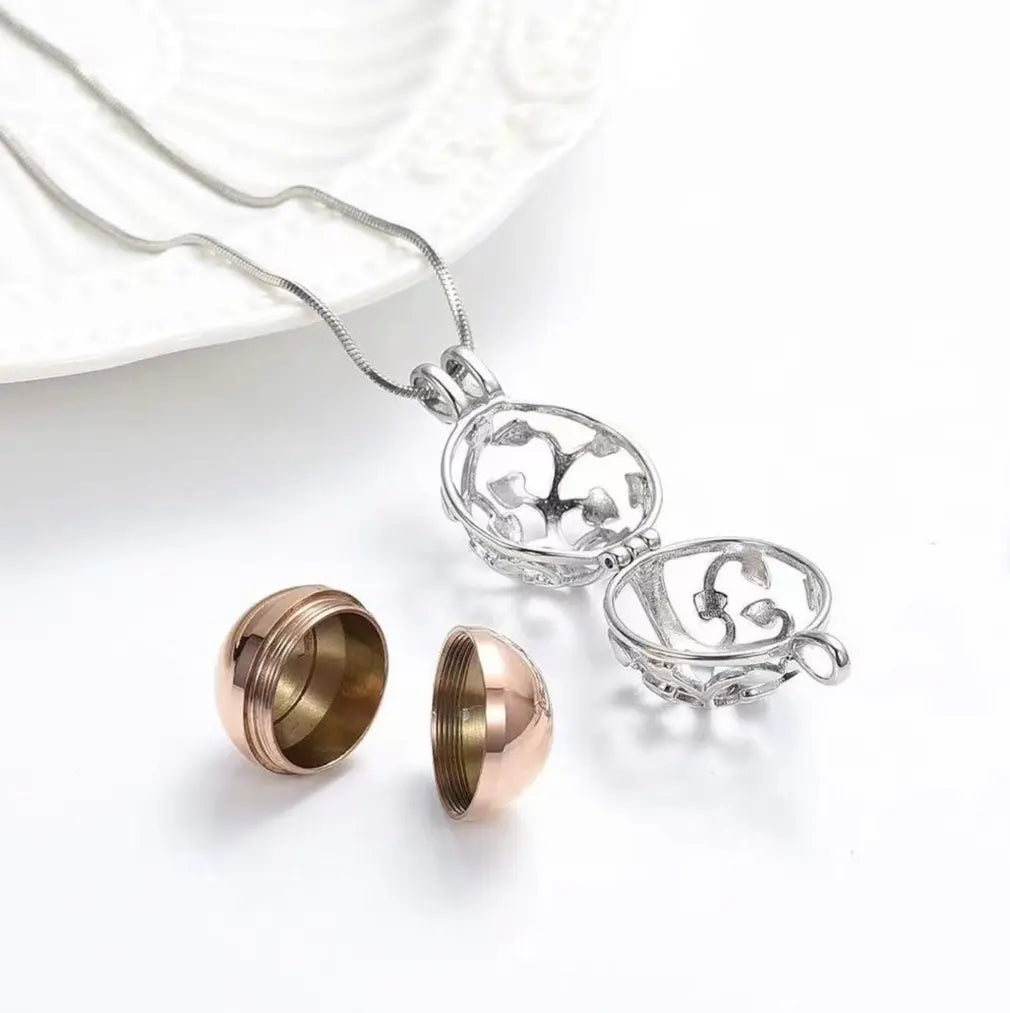 An open Tree of Life hollow locket showing the detachable threaded metal capsule.