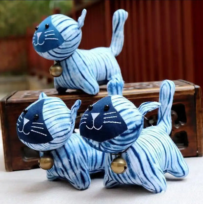A group of three hand-dyed indigo plush cats, showing the unique and one-of-a-kind patterns on each memorial keepsake.