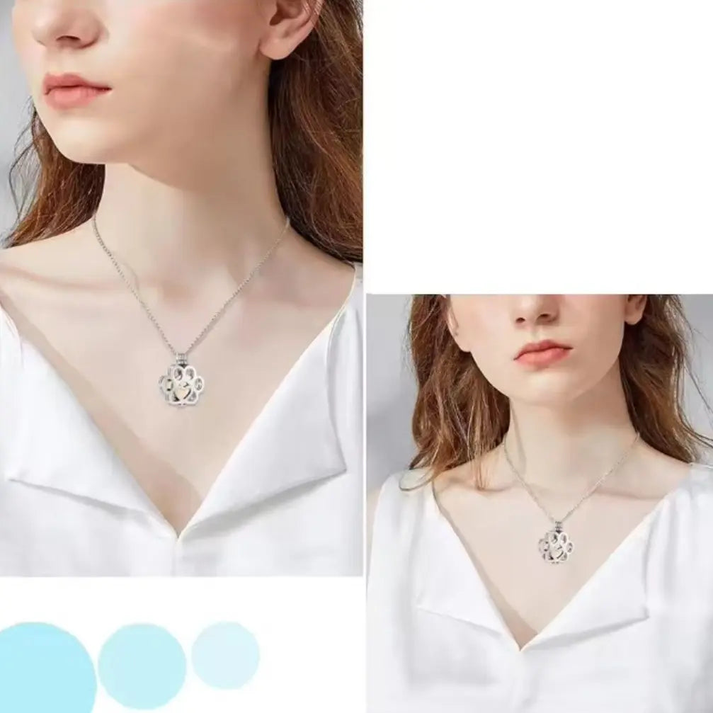 A female model wearing the polished silver hollow paw print urn necklace as an elegant pet fur memorial jewelry.